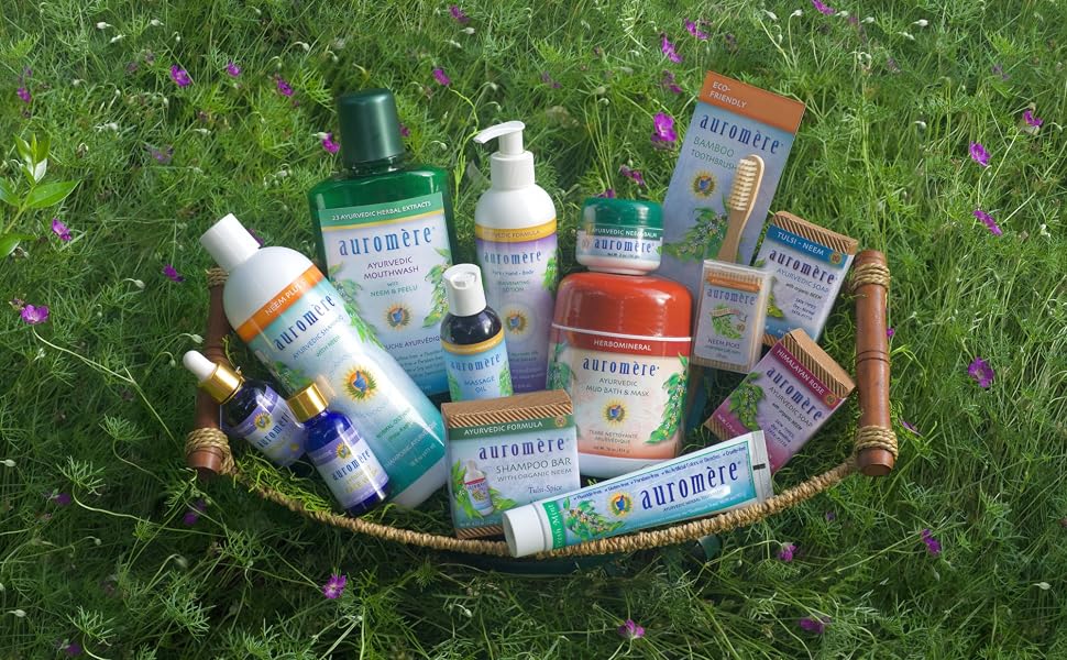 A basket containing a number of various Auromere products, on a natural grass background