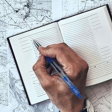 Photo shows person writing in travel planner with G2 pen