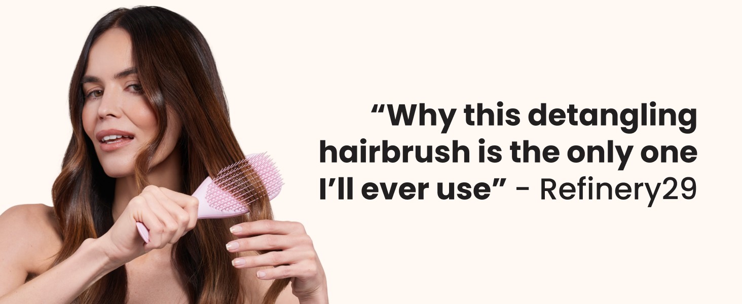A woman brushing her hair with a pink ultimate detangler brush.