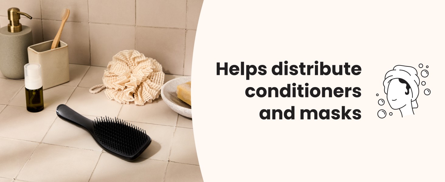 A black ultimate detangler brush laying on a bathroom counter.