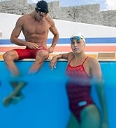 male and female athletes wearing arena team print swimsuits in red posing in the pool