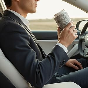 Professional in Tesla holding KOYASU Ti-Zen pure titanium tumbler during a luxury commute.