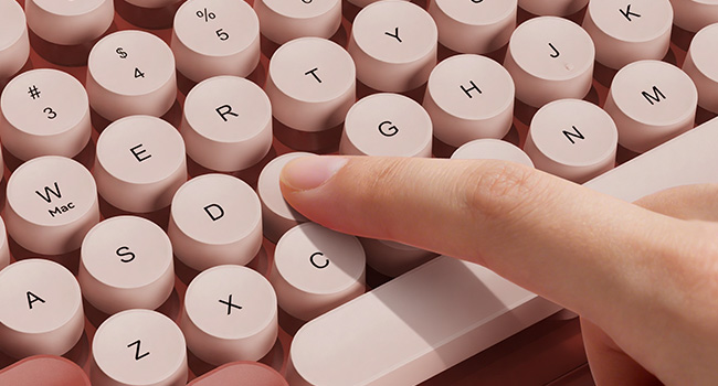 Close-up of burgundy retro keyboard round keycaps with smooth typing feel.