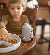 sippy cup in a high chair with snacks