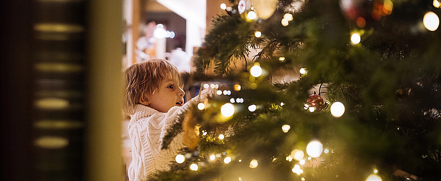Illuminated Christmas tree with twinkling lights creating a bokeh effect in the background, creating a festive holiday atmosphere.