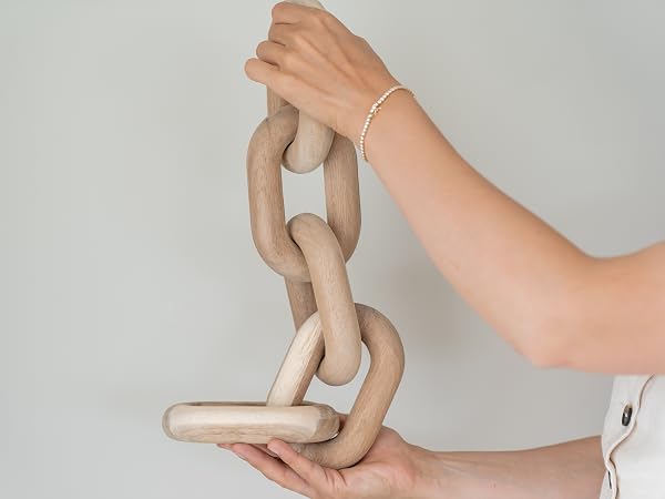 A pair of hands holding acacia wood chain