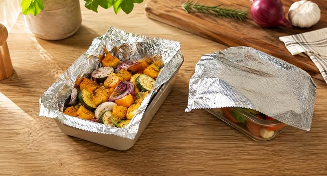 Embossed aluminum foil sheets lining a small pan and covering a food container.