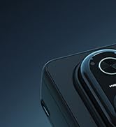 Close-up detail of dark circular mechanical component with metallic ring on navy blue background, partial product view.