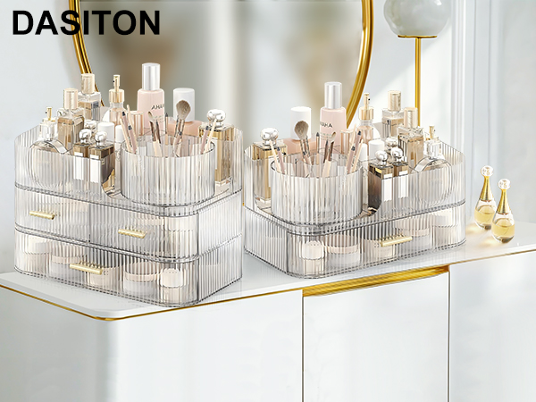 Clear acrylic makeup organizers with multiple compartments, storing various cosmetic products. Features gold handles and a tiered design for efficient storage and easy access.