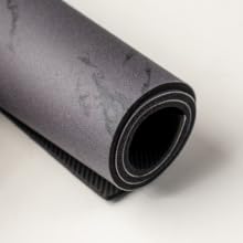 Rolled black marble coffee mat with flexible, cushioned, non-slip design.