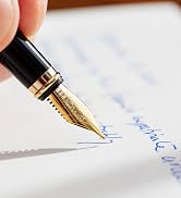 Black and gold fountain pen writing on paper with blue ink