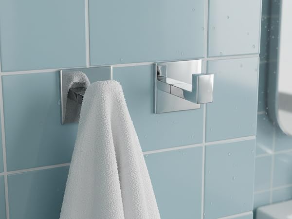 Modern bathroom interior with light blue tiled walls, featuring multiple mounted white fixtures and accessories.