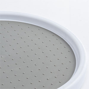 Close-up of a white circular object with perforated surface, possibly a shower head or speaker cover. Smooth outer rim visible.
