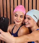 women wearing arena swim caps taking a selfie at the pool and smiling at the camera