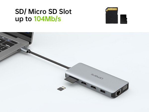 Silver USB-C hub adapter with multiple ports including SD/Micro SD card slot supporting speeds up to 104Mb/s, shown connected to a laptop.