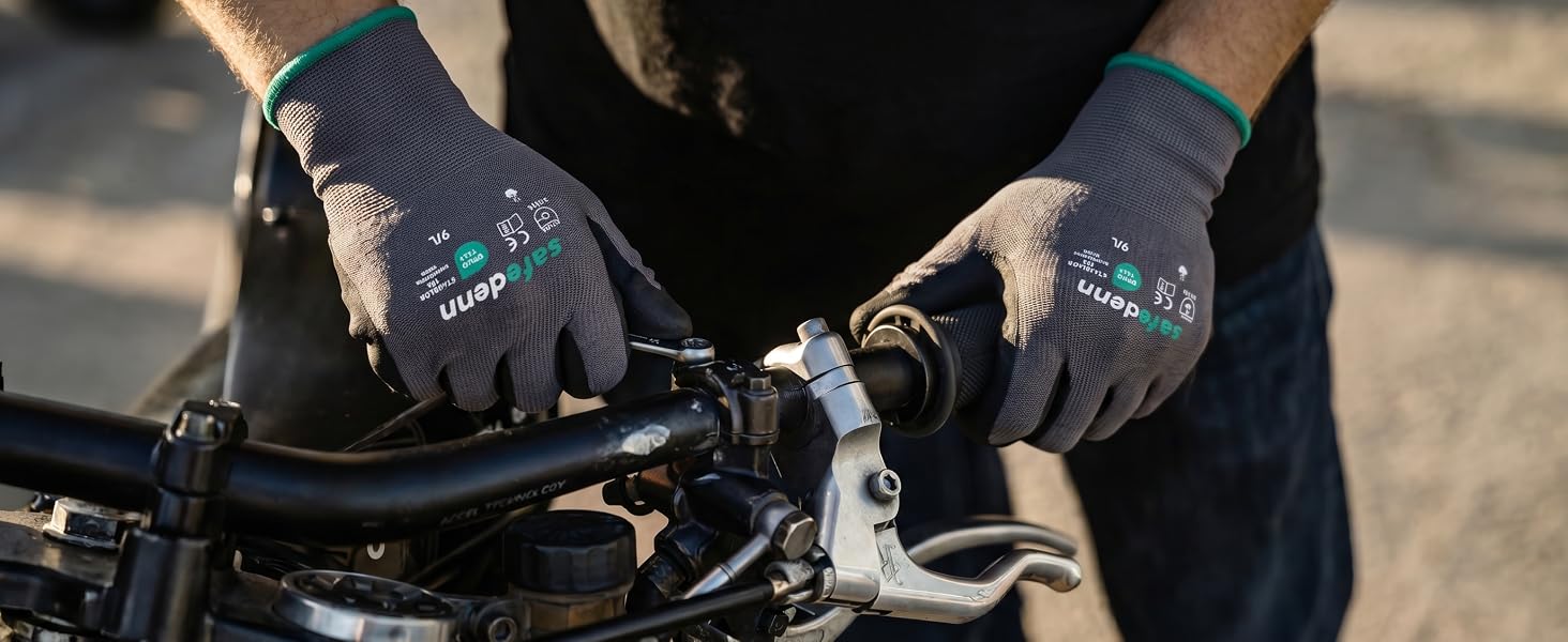 Safedenn nitrile-coated mechanic gloves being used with a wrench for motorcycle engine repair.