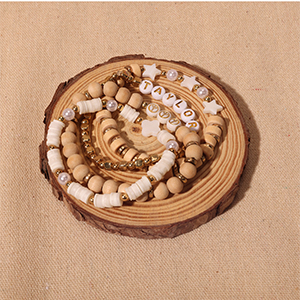 Two bracelets on the wooden piece of the table with smiley pearl bracelets and love bracelets