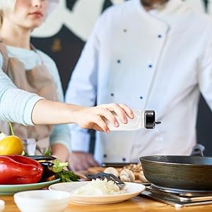 Chef adding salt to dish