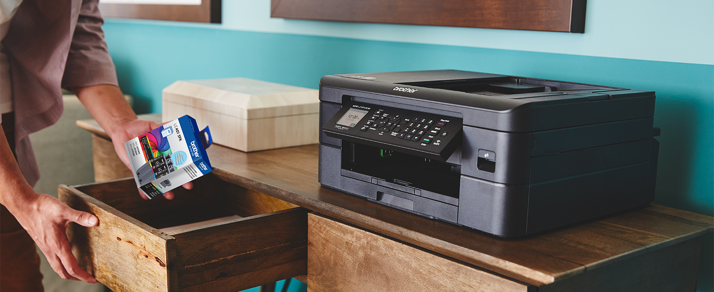 Person picking up LC401 ink cartridges from desk drawer