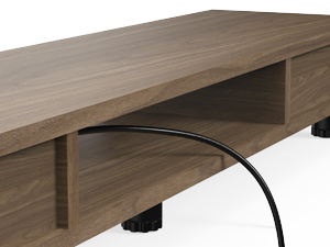 Wooden entertainment center or TV stand with open shelf and cable management hole. Light wood finish with black metal feet visible.