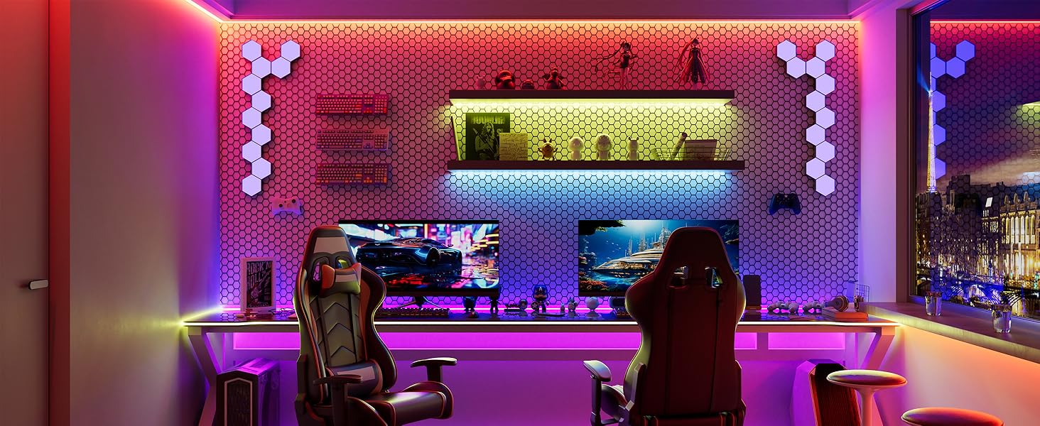 Modern gaming setup with colorful LED lighting, featuring racing-style chairs, multiple monitors, and a decorative hexagonal wall panel background. The room has a vibrant, futuristic ambiance.