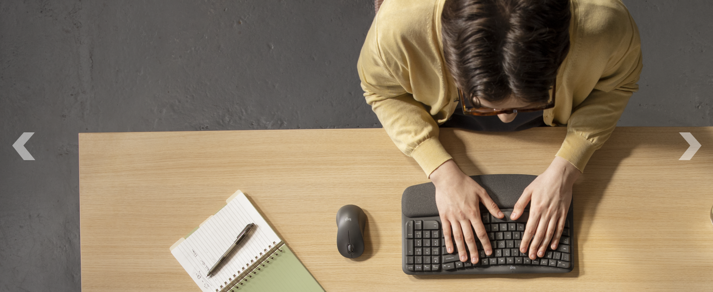 zoom of a man typing on wave keys for business wireless ergonomic compact keyboard