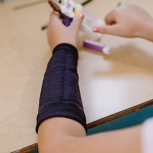 kid with arm weight doing fine motor tasks