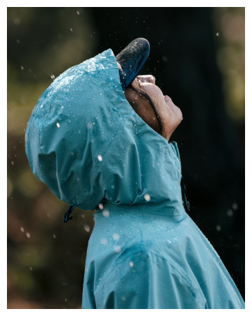 Women staring up at rainy sky wearing rain jacket and hat