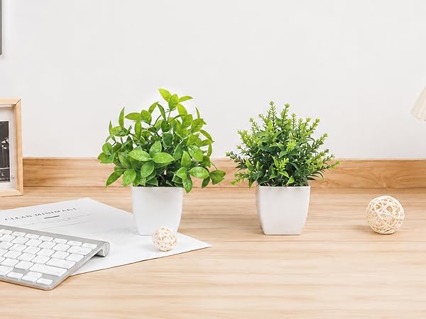 two artificial green plants white pots office desk decor