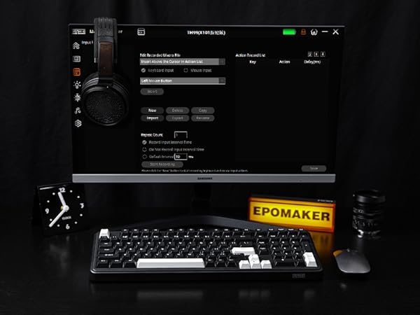 Desktop setup with black keyboard, mouse, headphones, and clock. Computer screen displays dark interface. Yellow 'EPOMAKER' text visible on keyboard or nearby item.