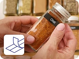 Label tape being pulled off split backing, person applying P-touch Btag label "CHILI" on spice jar