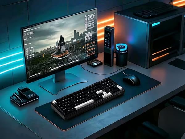 Gaming setup with large monitor displaying cityscape, mechanical keyboard, mouse, desktop computer, and LED lighting. Desk features sleek black accessories and blue ambient glow.