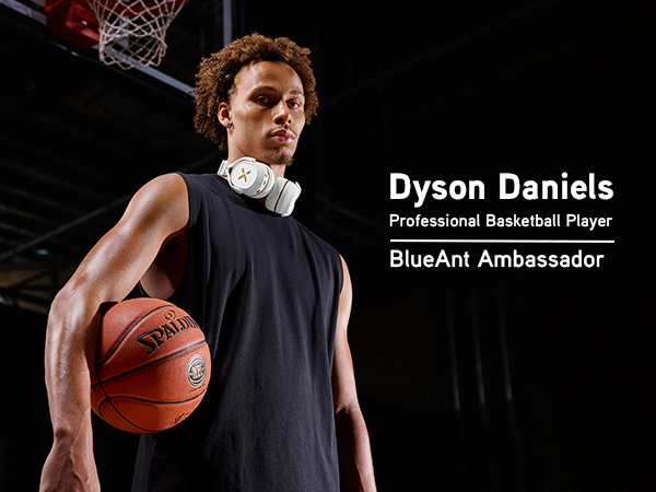 Dyson Daniels on an basketball court wearing white Pump X headphones around his neck