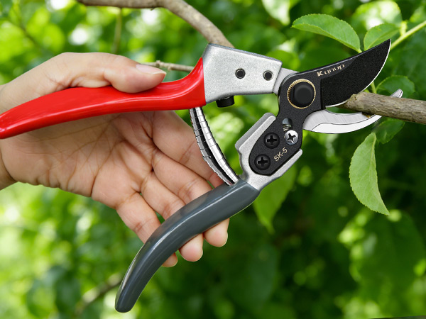 Series of close-up shots showing garden pruning or cutting tool in use among green foliage, demonstrating precise cutting action on plants.