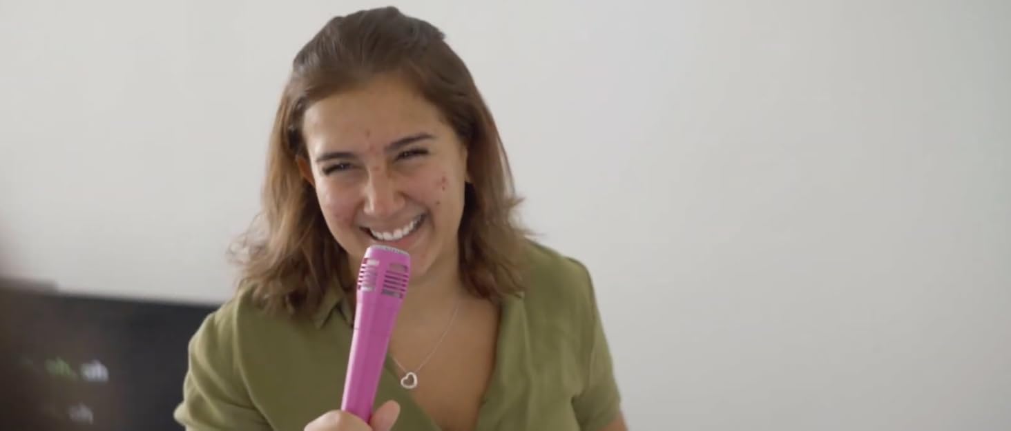 Lady smiling whilst singing using a at home karaoke machine