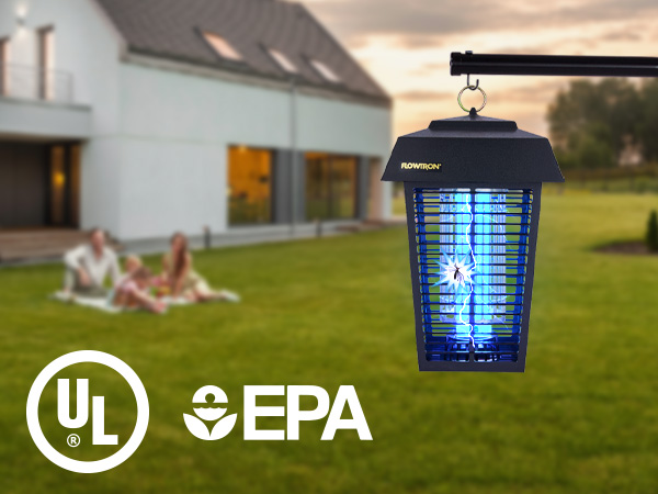 Bug zapper with bright blue light in large backyard with a family sitting on a blanket