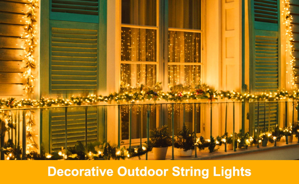 Decorative outdoor string lights illuminating a house exterior, draped along a porch railing with green shutters visible.