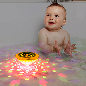 a baby playing with a light toy in a bathtub.