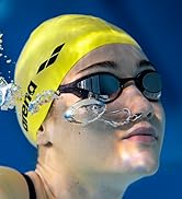 woman wearing a yellow arena swim cap and arena swim goggles under water in a pool