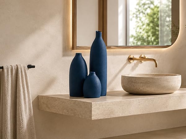 Coastal blue ceramic vase set on a laundry room countertop with natural wood cabinets.