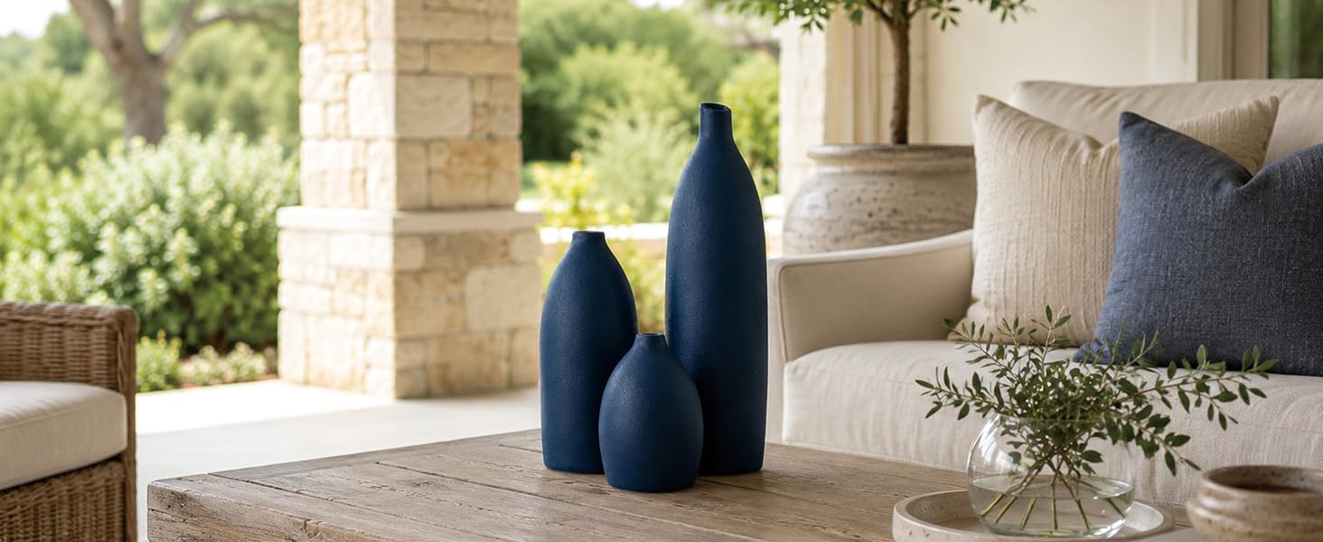 Matte coastal blue ceramic vase set on a wood console table with dried flowers.