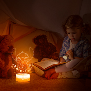 LED night light displaying Stitch character design, casting warm amber glow in dark room setting.