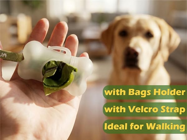 Text reads: 'with Bags Holder with Velcro Strap Ideal for Walking'. Shows close-up of white plastic holder with green material, demonstrating attachment method.