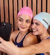 women wearing arena swim caps taking a selfie at the pool and smiling at the camera