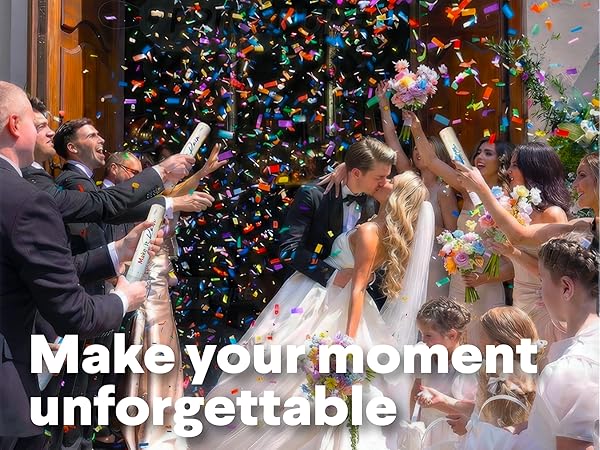 Bride and groom kissing while guests shoot confetti cannons at joyful wedding