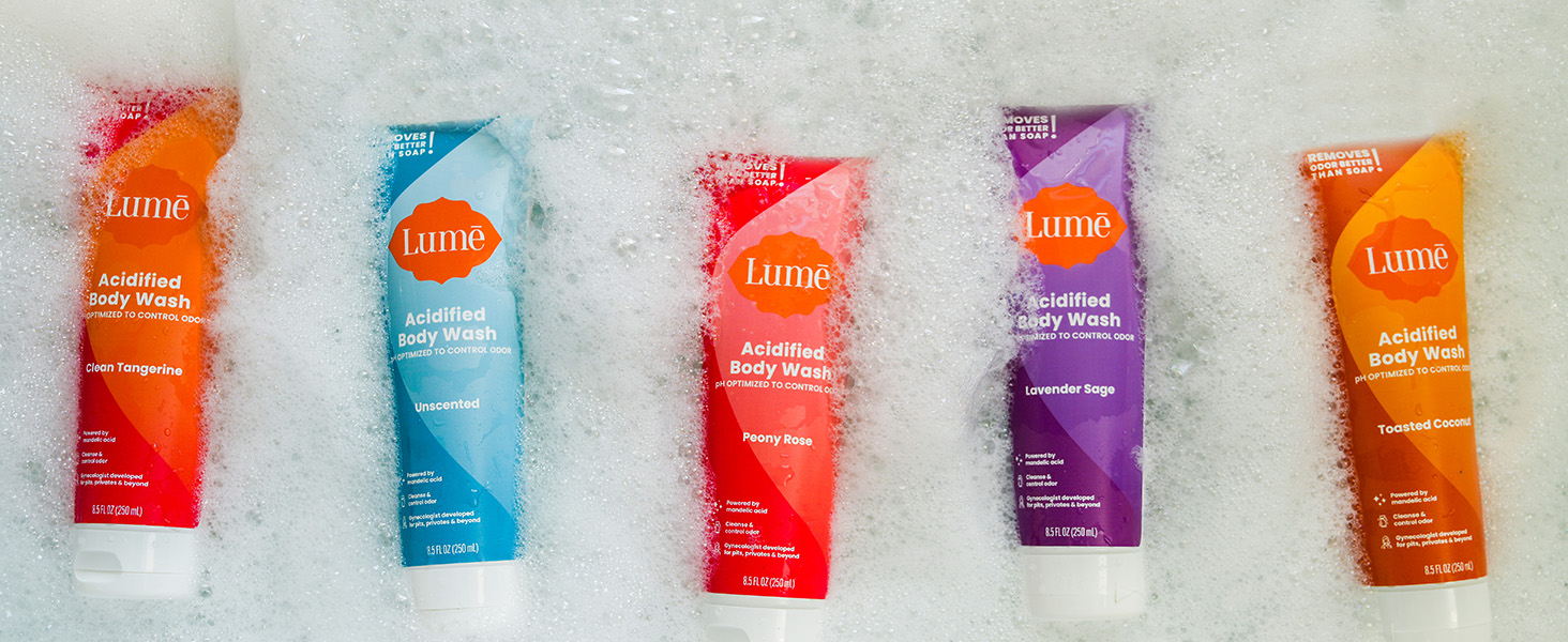 Lume Acidified Body Wash in available scents floating in a bath tub