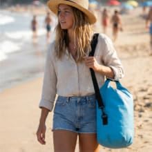 Woman carrying waterproof dry bag at beach for travel swimming and outdoor gear