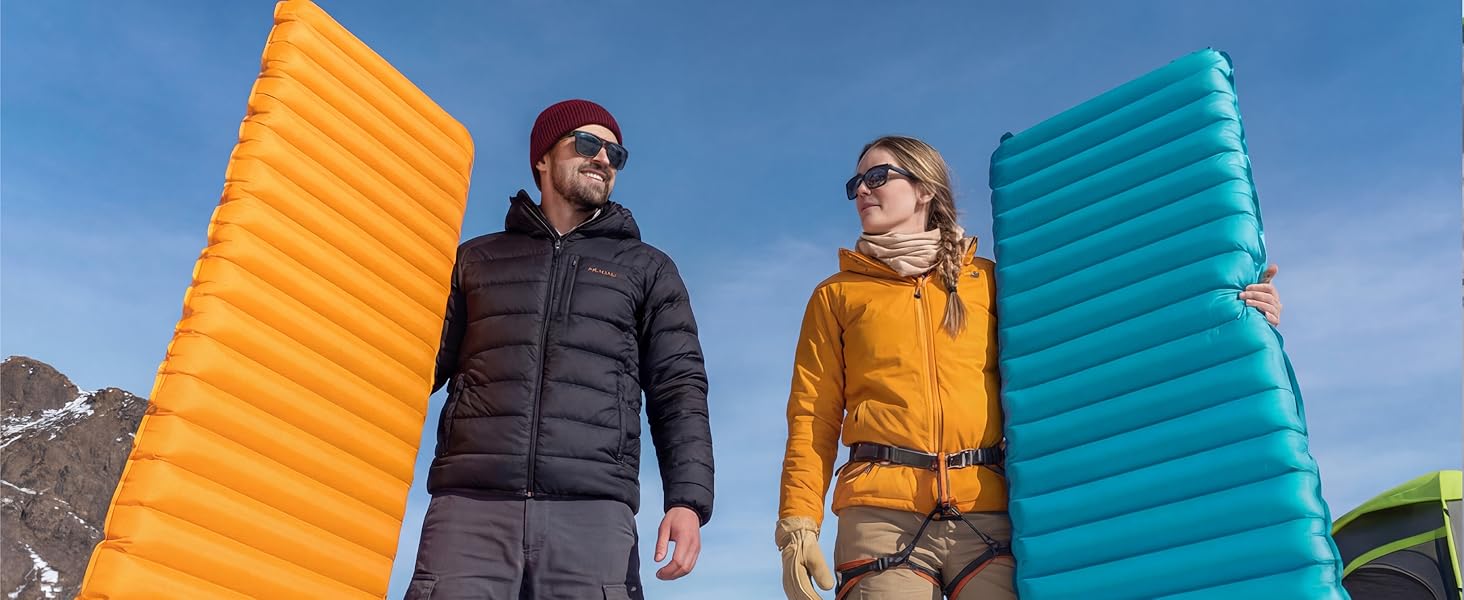 Couple holds Airlive2000 pads at mountain camp, ready to rest.