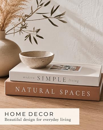 Decorative storage books styled with natural botanicals and a ceramic bowl