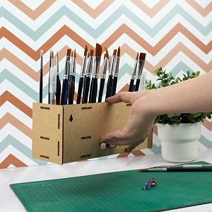 a hand holding a box of paint brushes